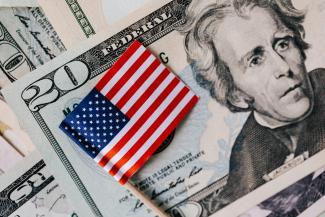 Close-up of American flag on US dollar bills symbolizing finance and economy.