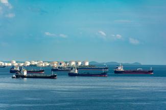 Cargo Ships Anchored at Coastal Port under Blue Sky