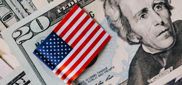 Close-up of American flag on US dollar bills symbolizing finance and economy.