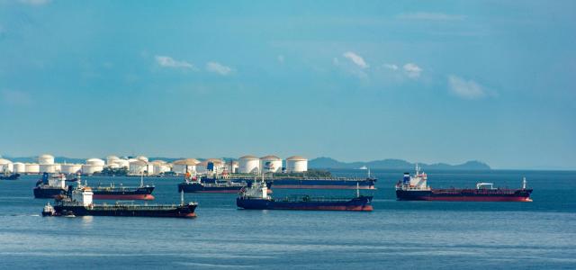 Cargo Ships Anchored at Coastal Port under Blue Sky